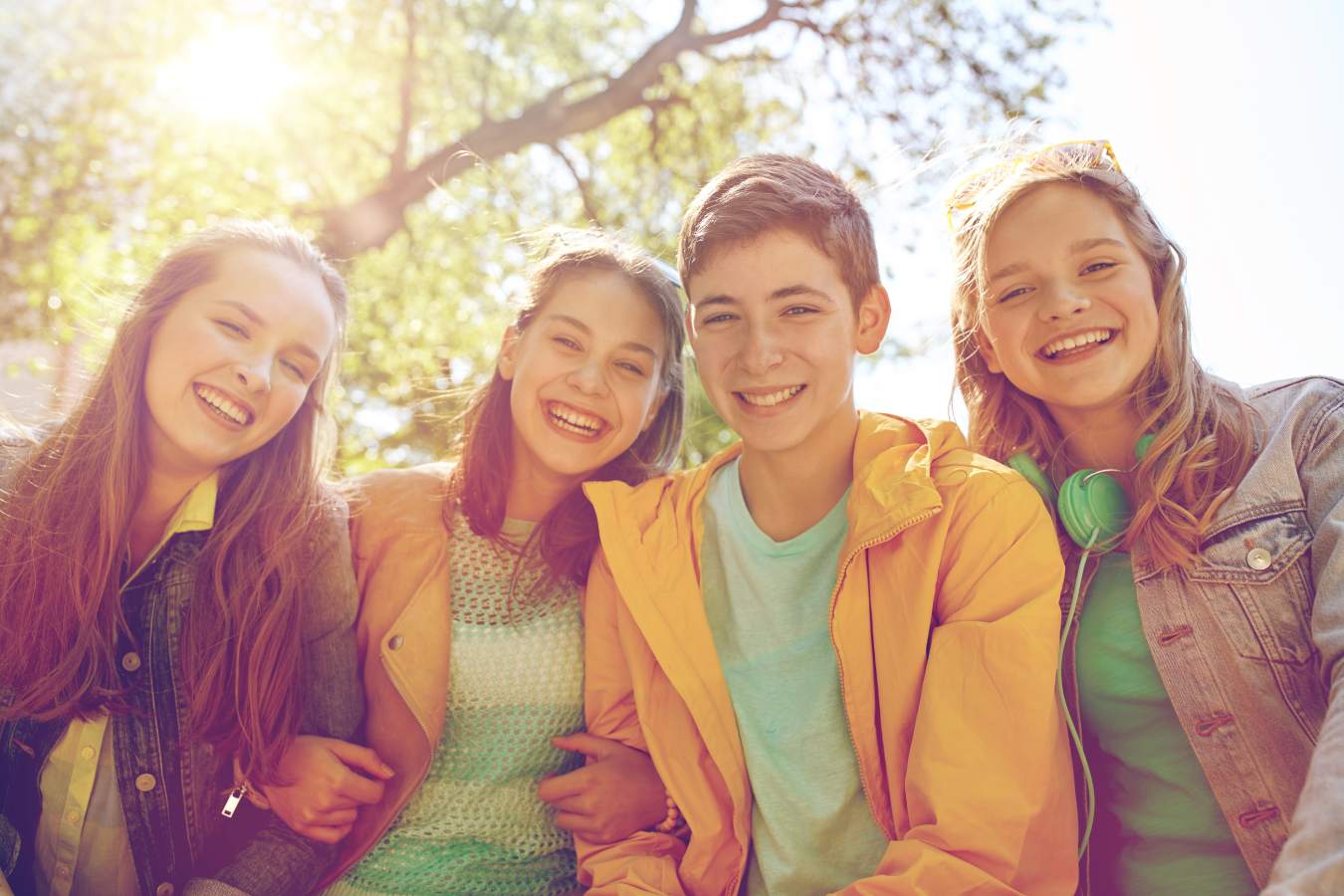 Four teens sitting together and smiling