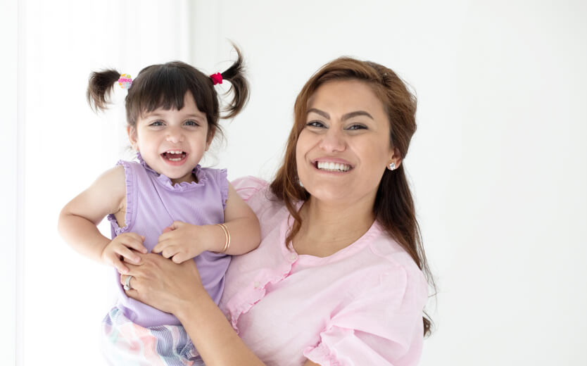 Woman holding young girl and smiling